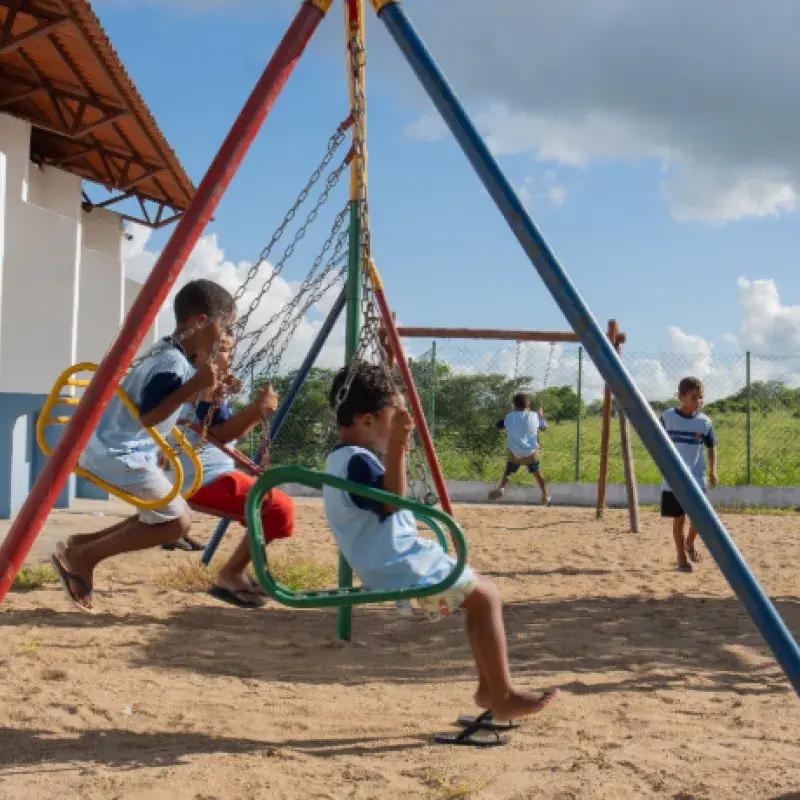 crianças brincam em um balanço ao ar livre